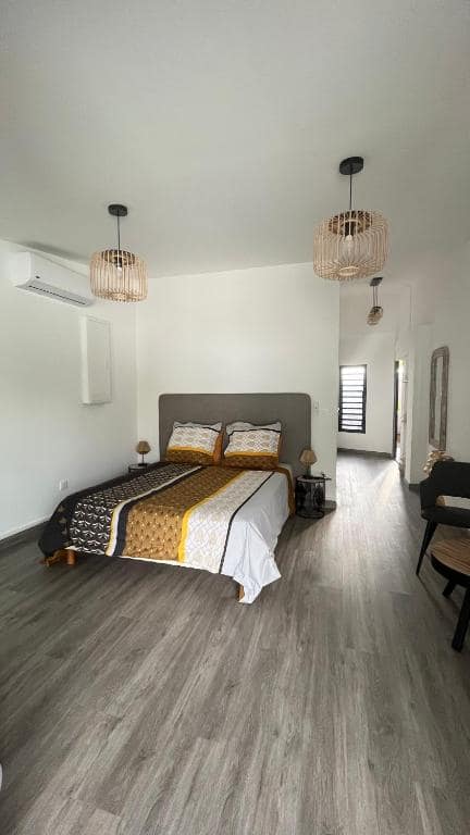 Chambre principale, grand lit et lustres en rotin · © ATÈRLA
