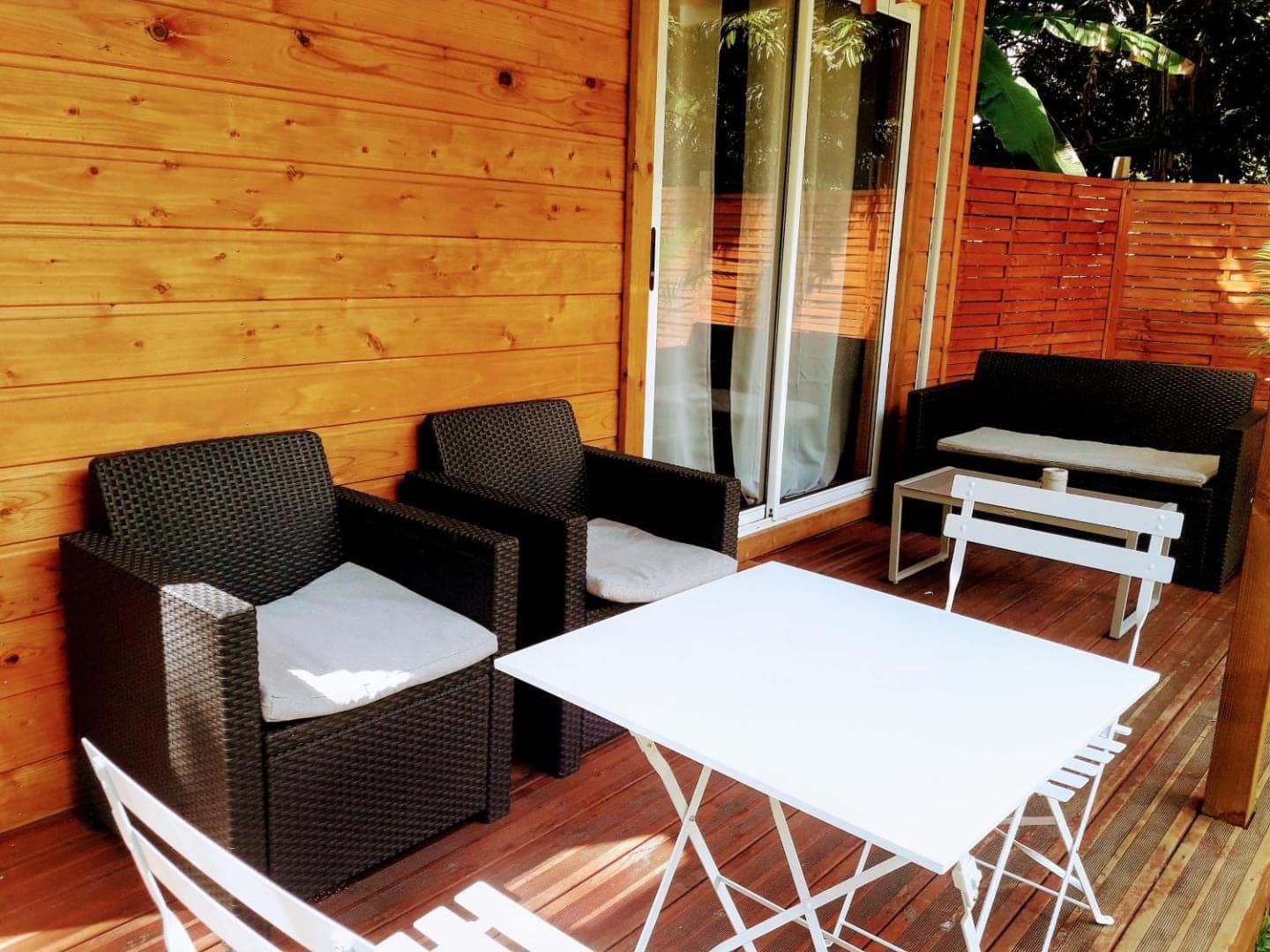 Terrasse en bois, fauteuils et table blanche · © Bunga-lodge Vanille