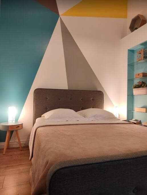 Autre angle de la chambre, triangle jaune au sommet du mur · © Les Songes