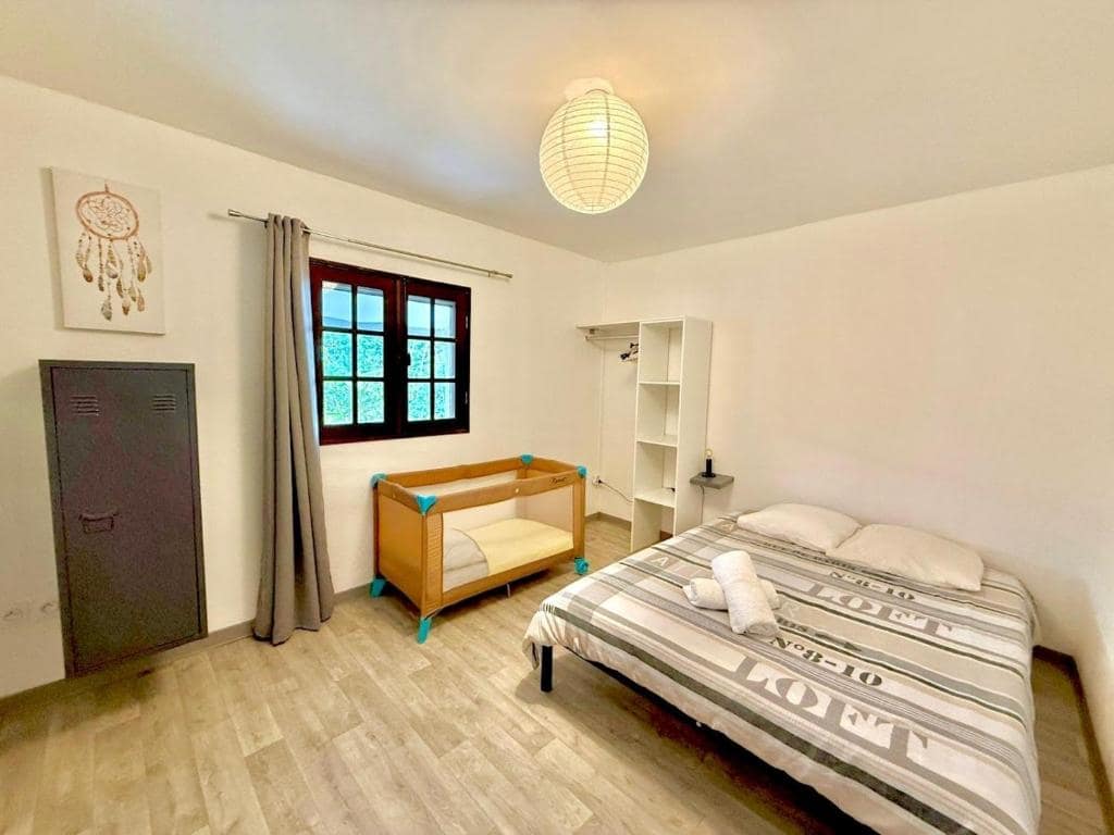 Chambre à grand lit avec berceau d'appoint pour enfant en bas âge · © Case Hermione – Vue Montagne à Hell-Bourg