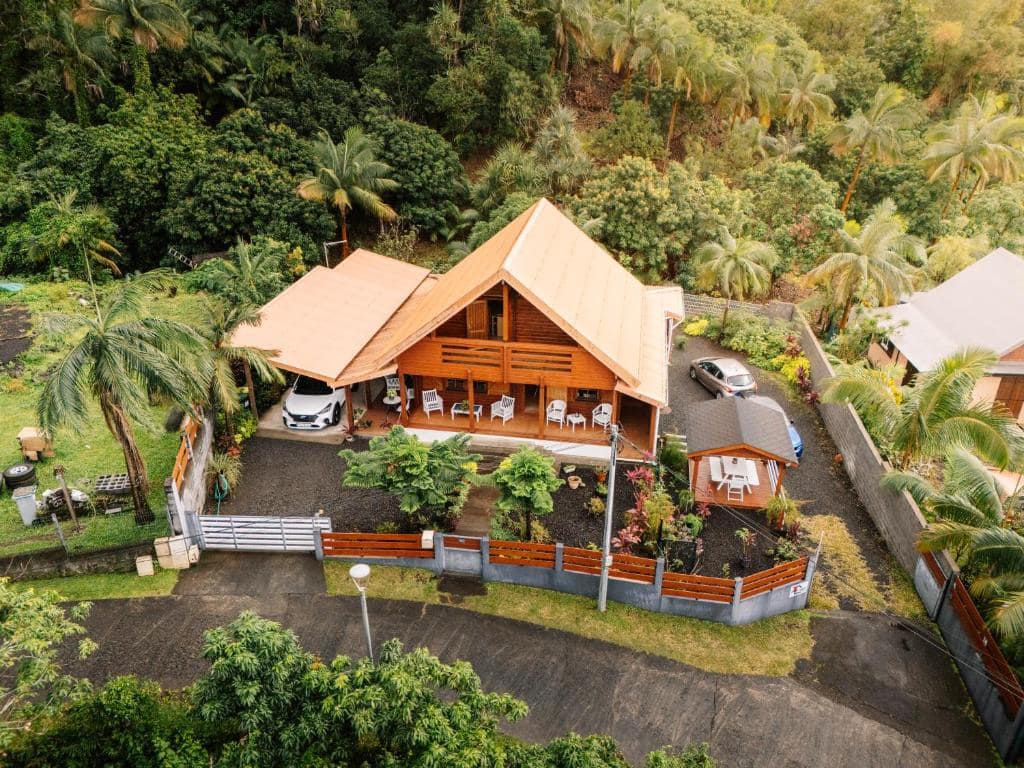 Chalet bois entouré de végétation tropicale · © Chalet des Laves