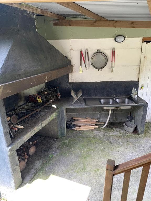 Cuisine d'été extérieure avec barbecue maçonné et double évier · © Chalets Medinilla