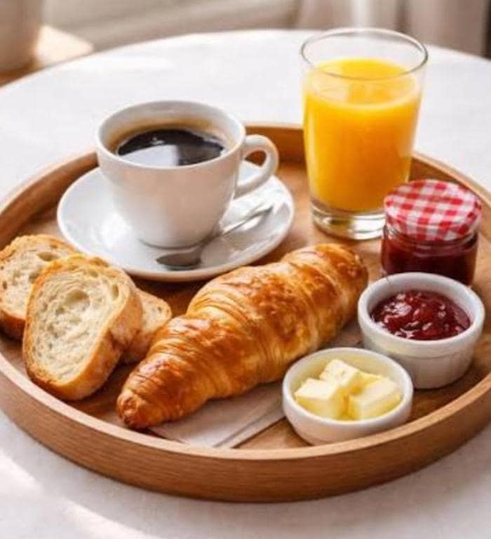 Plateau petit-déjeuner viennoiseries, café et jus d'orange · © Chez JP Lilou