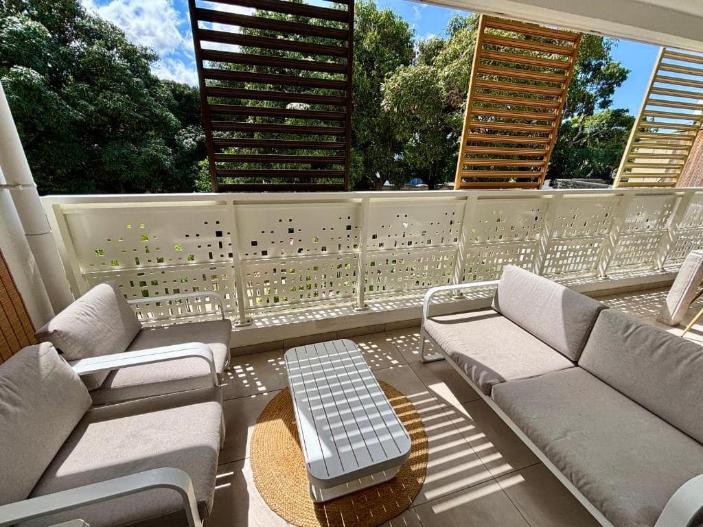 Terrasse ombragée avec canapé et fauteuils lounge · © Cosy Sand