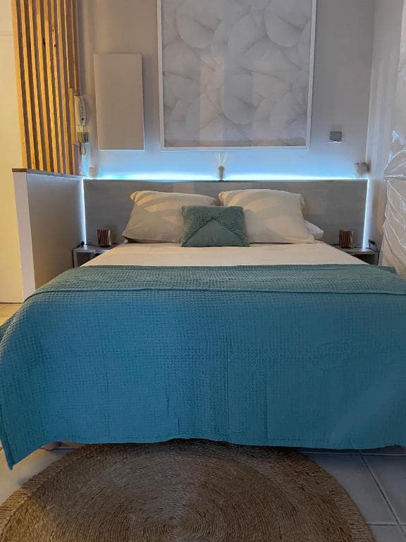 Chambre à literie turquoise, tapis jute rond · © Le Cœur Daisy'L