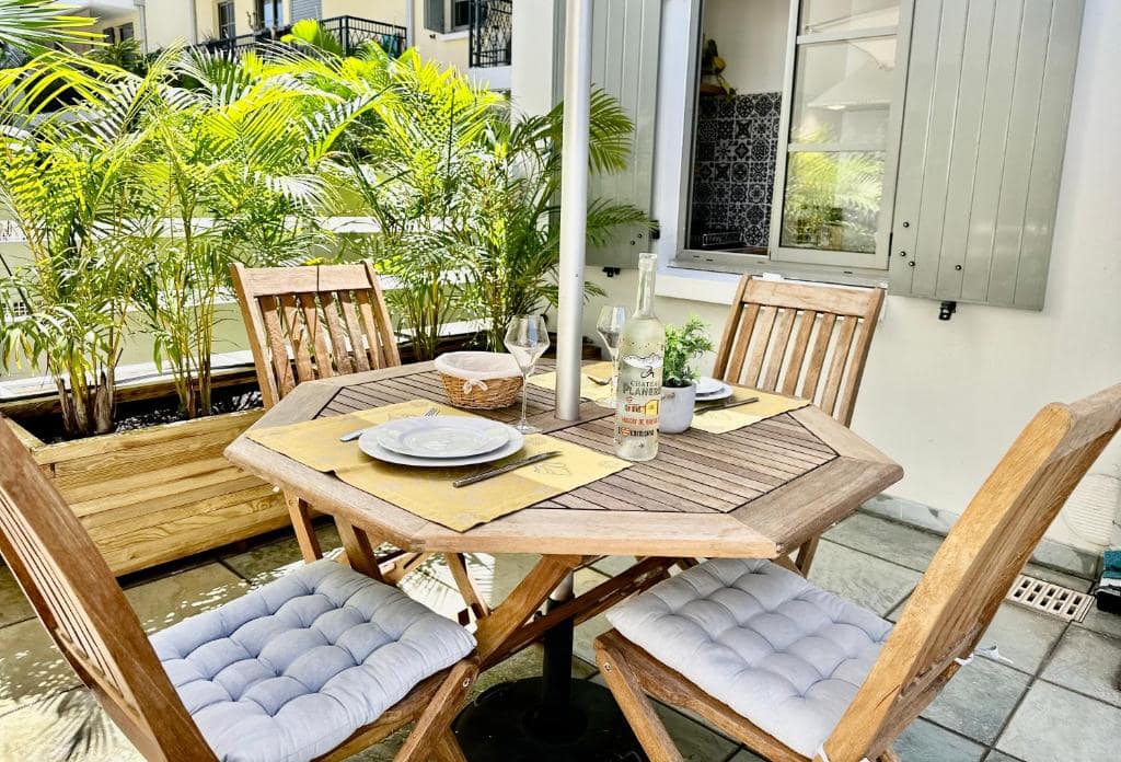 Terrasse table bois, palmiers en pot · © Le Cœur Daisy'L