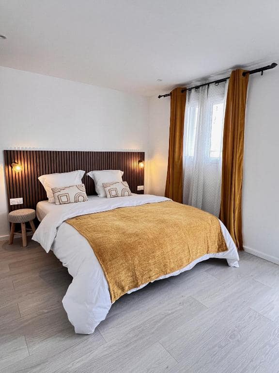 Autre chambre, plaid moutarde et rideaux ocres · © L'Enclos du Volcan