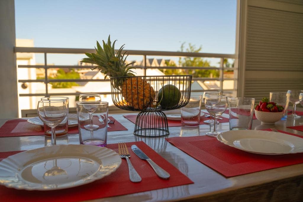 Table du balcon dressée face au coucher de soleil · © Évasion Saint-Leu