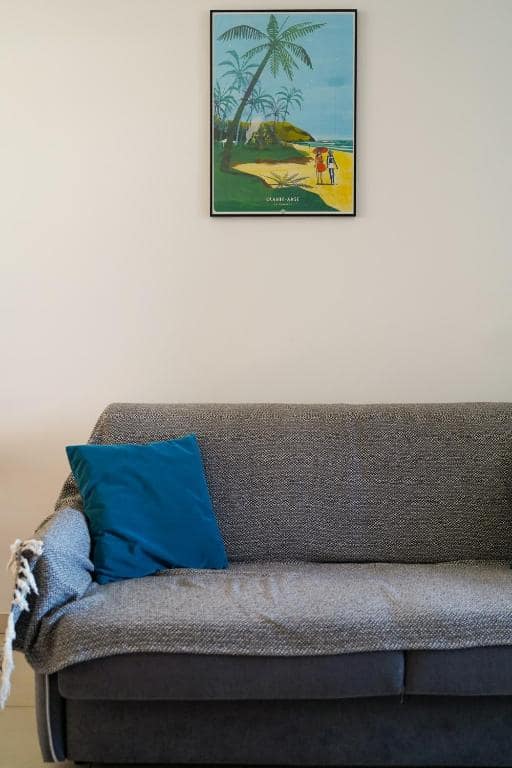 Canapé convertible avec affiche Grande Anse encadrée · © Évasion Saint-Leu