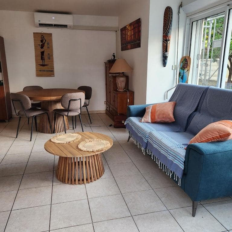 Canapé bleu et coin repas avec toiles africaines · © F2 Jardin