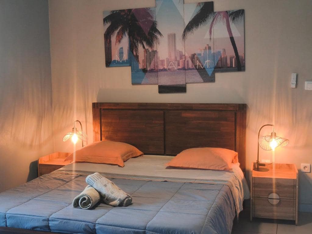 Chambre lit double, décor tropical · © Gîte Route des Laves