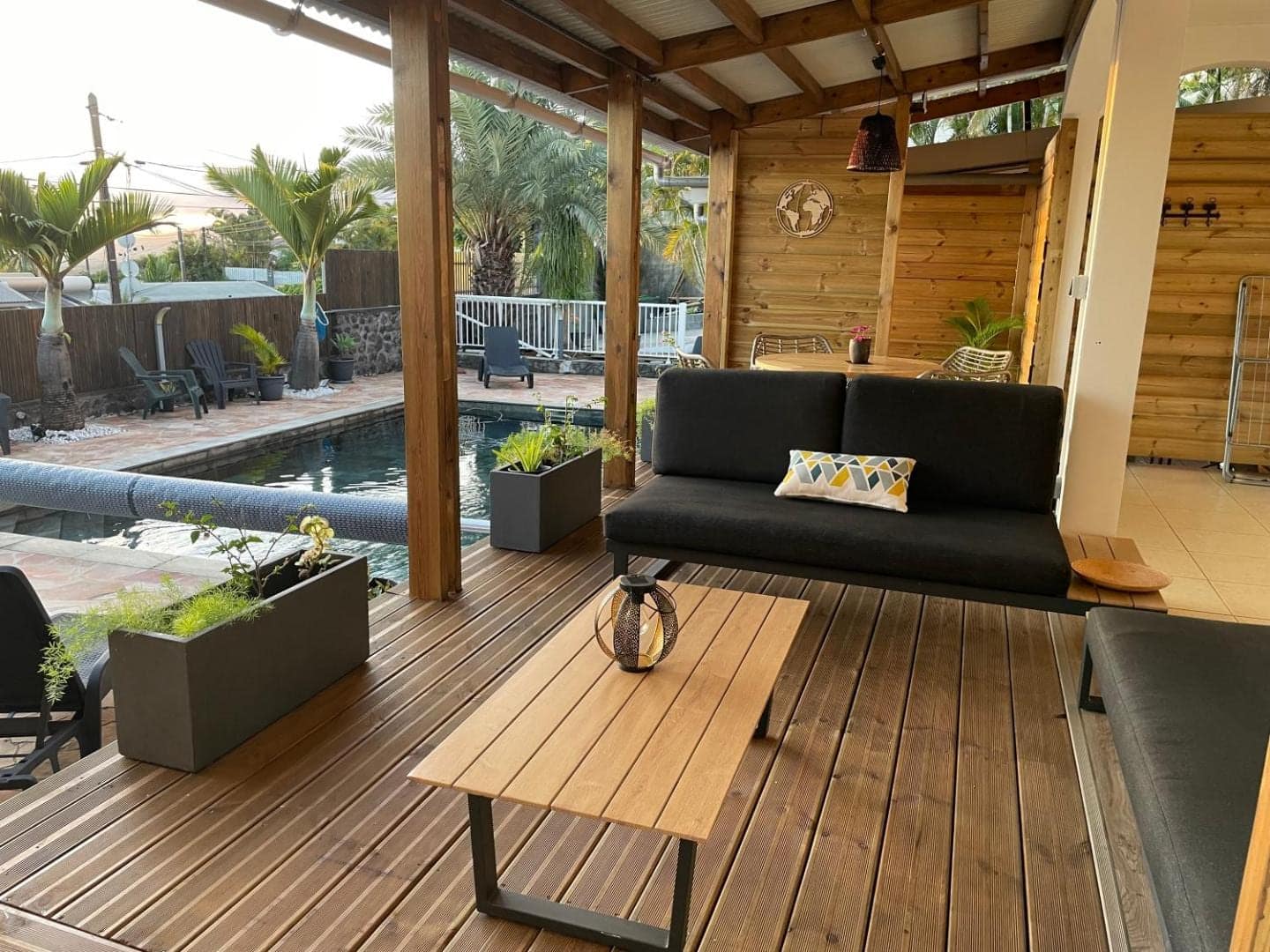 Terrasse bois couverte, salon face au bassin · © Villa des 4 Sens