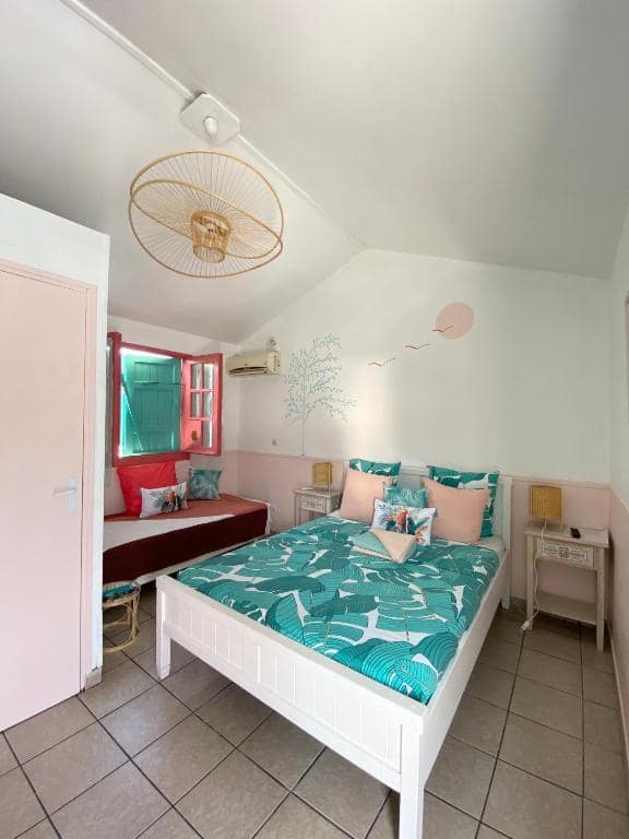 Chambre à déco pastel, mur peint d'oiseaux · © Hôtel De la Plage
