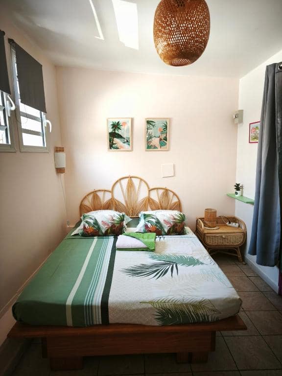 Chambre à tête de lit rotin, affiches encadrées · © Hôtel De la Plage