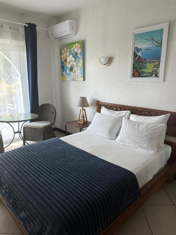 Chambre avec cadres et fauteuils, ouverture jardin · © Hôtel Résidence Le Phoenix
