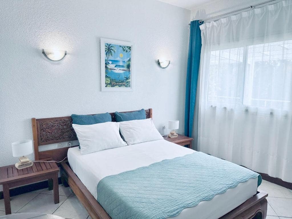 Chambre à tête de lit sculptée, poster Manapany · © Hôtel Résidence Le Phoenix