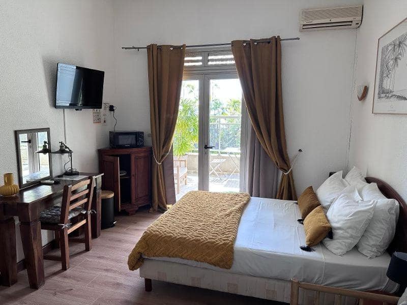 Chambre avec télévision, bureau et coin repas privé · © Hôtel Résidence Le Phoenix