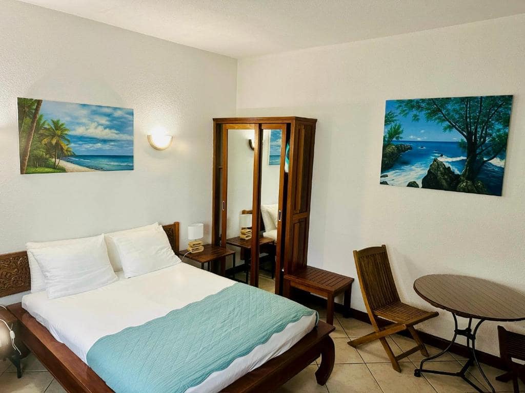Chambre au dessin palmiers, dressing et bureau · © Hôtel Résidence Le Phoenix