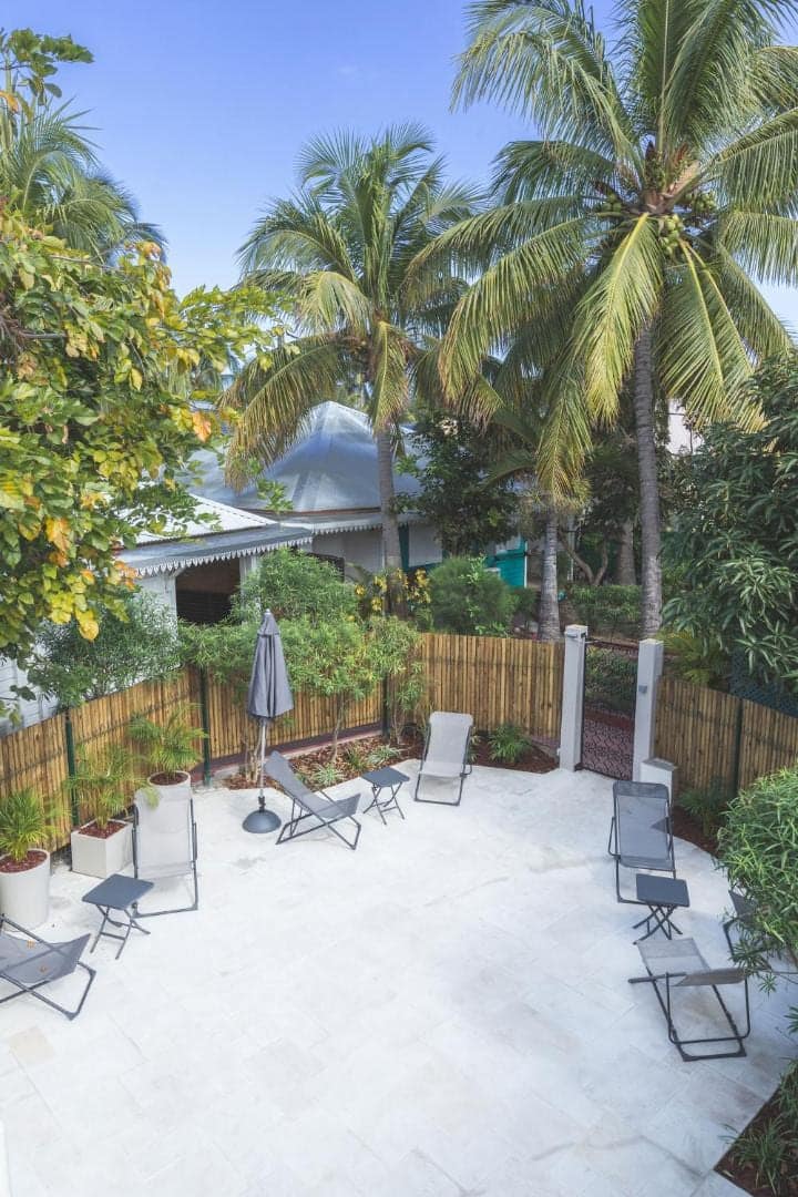 Terrasse close de bambou, parasol et transats · © Ilet du Lagon