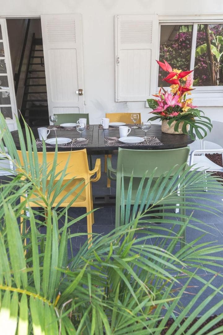 Table dressée en terrasse, bouquet de fleurs · © Ilet du Lagon