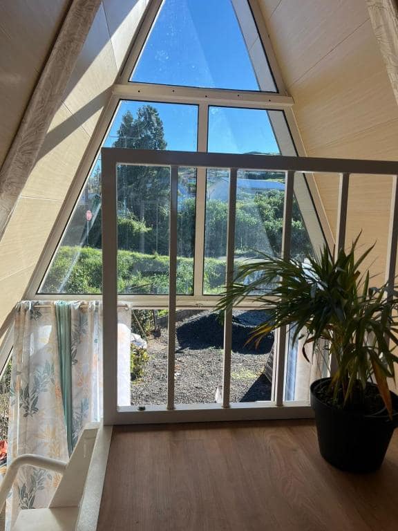 Vue intérieure de la baie vitrée triangulaire côté jardin · © Kaz triang