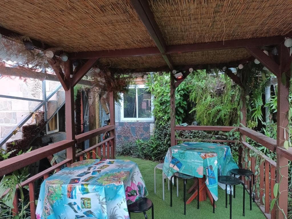 Varangue sous auvent végétal, tables aux nappes créoles · © La baie rose