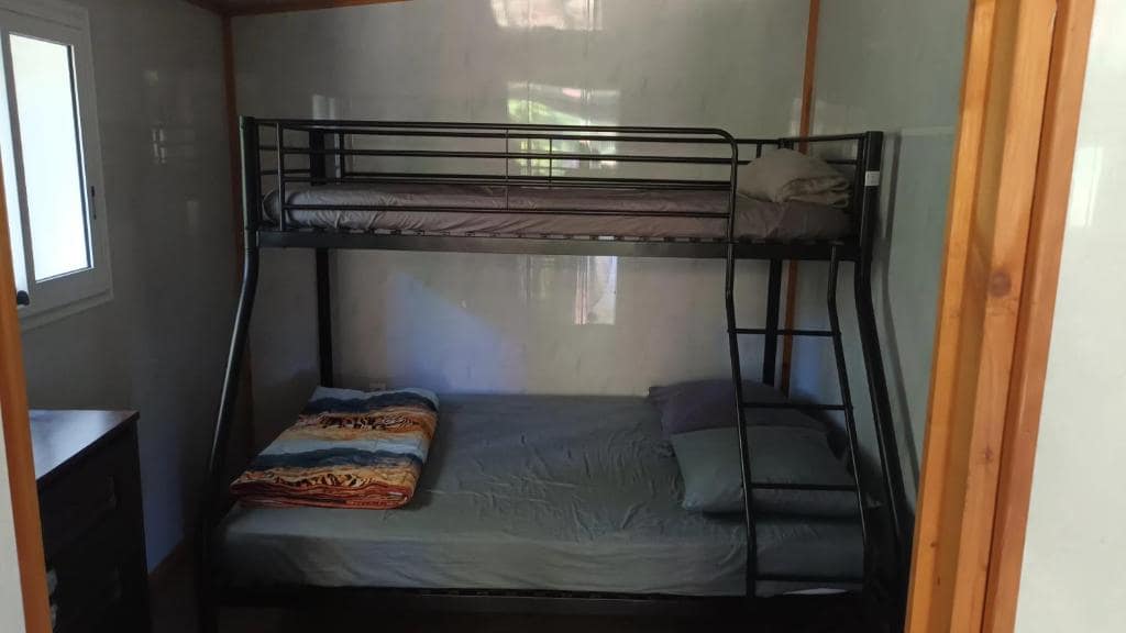 Chambre équipée de lits superposés avec échelle métallique · © La cacaoyère
