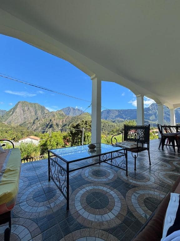 Salon de terrasse en fer forgé, table basse et vue montagne · © La Salazienne