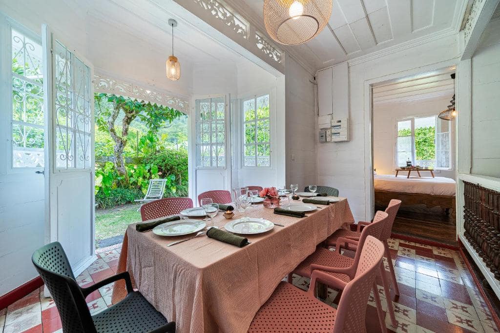 Salle à manger véranda, longue table dressée face au jardin · © La Villa Blanche