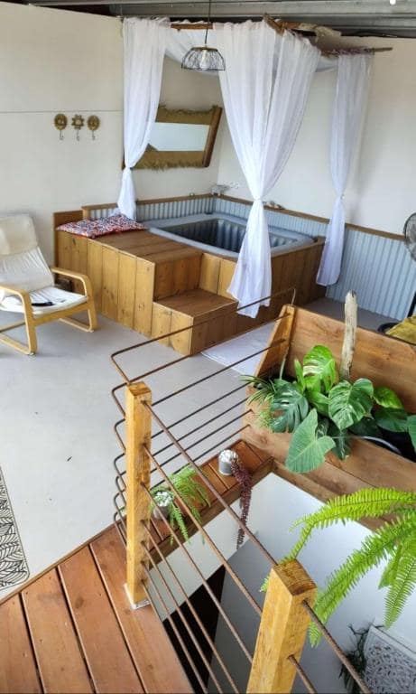 Bain à remous carré à l'étage, voilage blanc et fauteuil œuf · © l'Antre Temps
