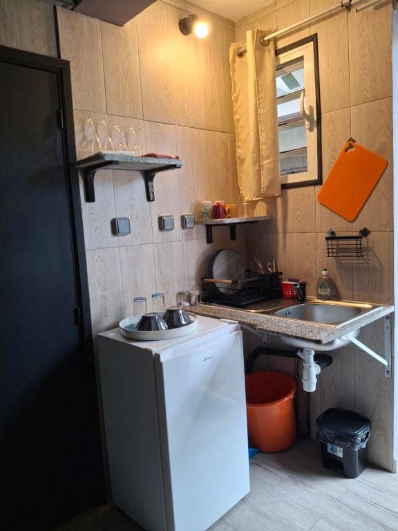 Kitchenette du studio 1, évier et petit réfrigérateur · © Bivouac Maïdo