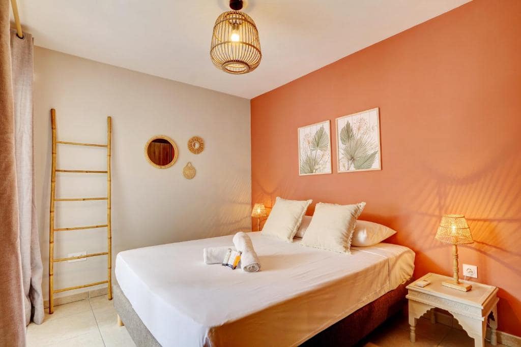 Chambre avec mur orangé et échelle en bambou · © Le Céladon