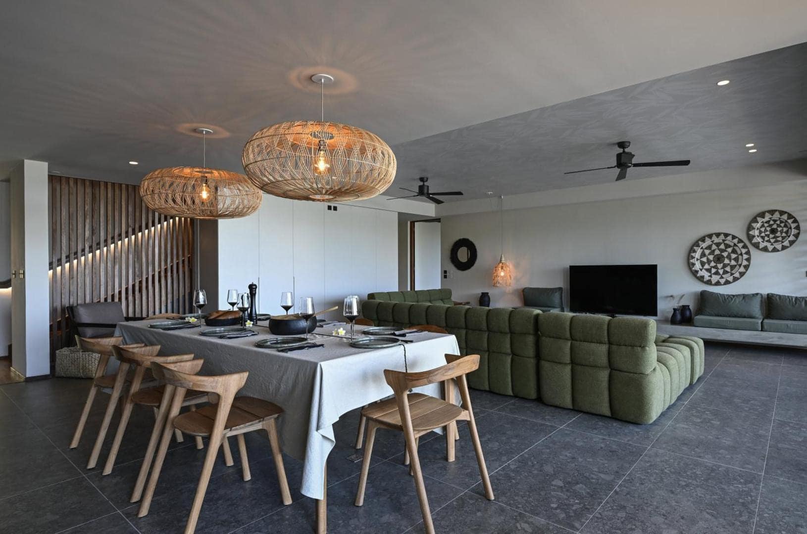 Séjour ouvert, canapé vert et grande table dressée · © Domaine des Manguiers