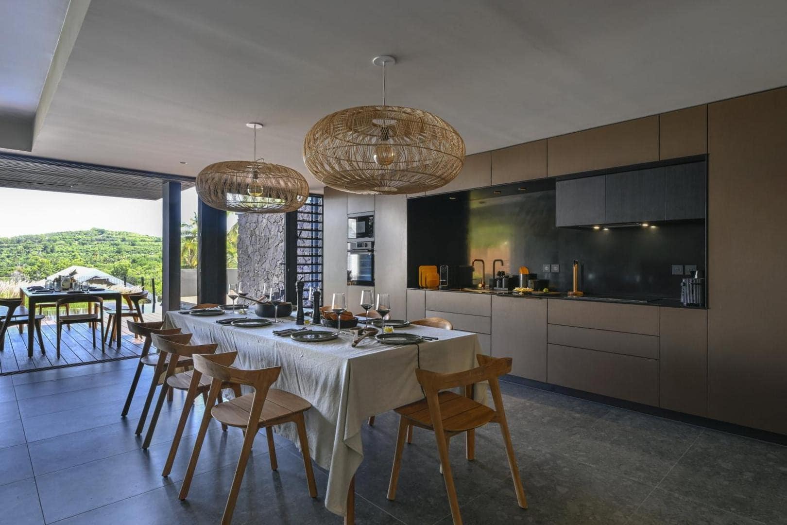 Cuisine en îlot et suspensions de rotin · © Domaine des Manguiers