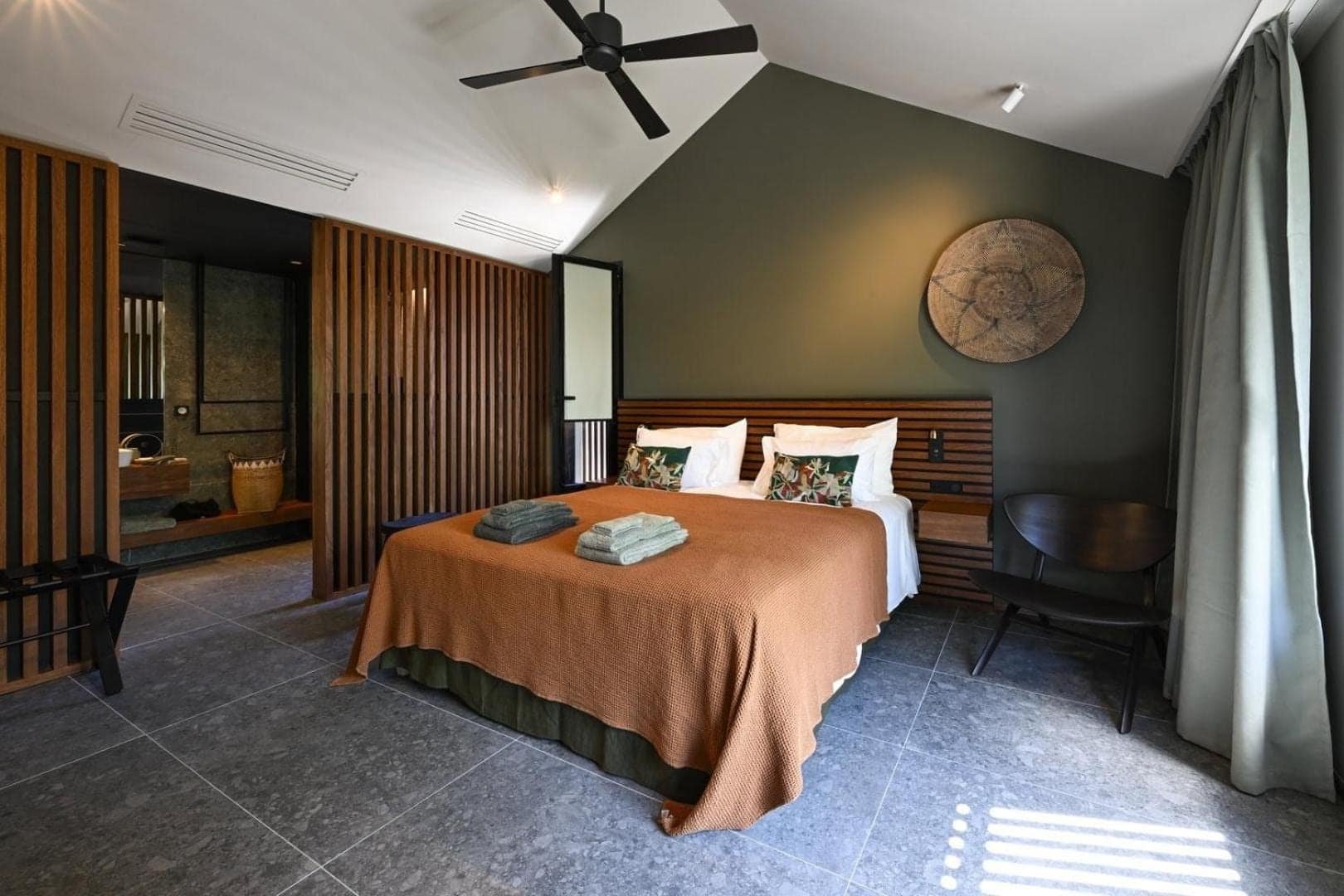 Chambre au linge terracotta, claustra de bois · © Domaine des Manguiers