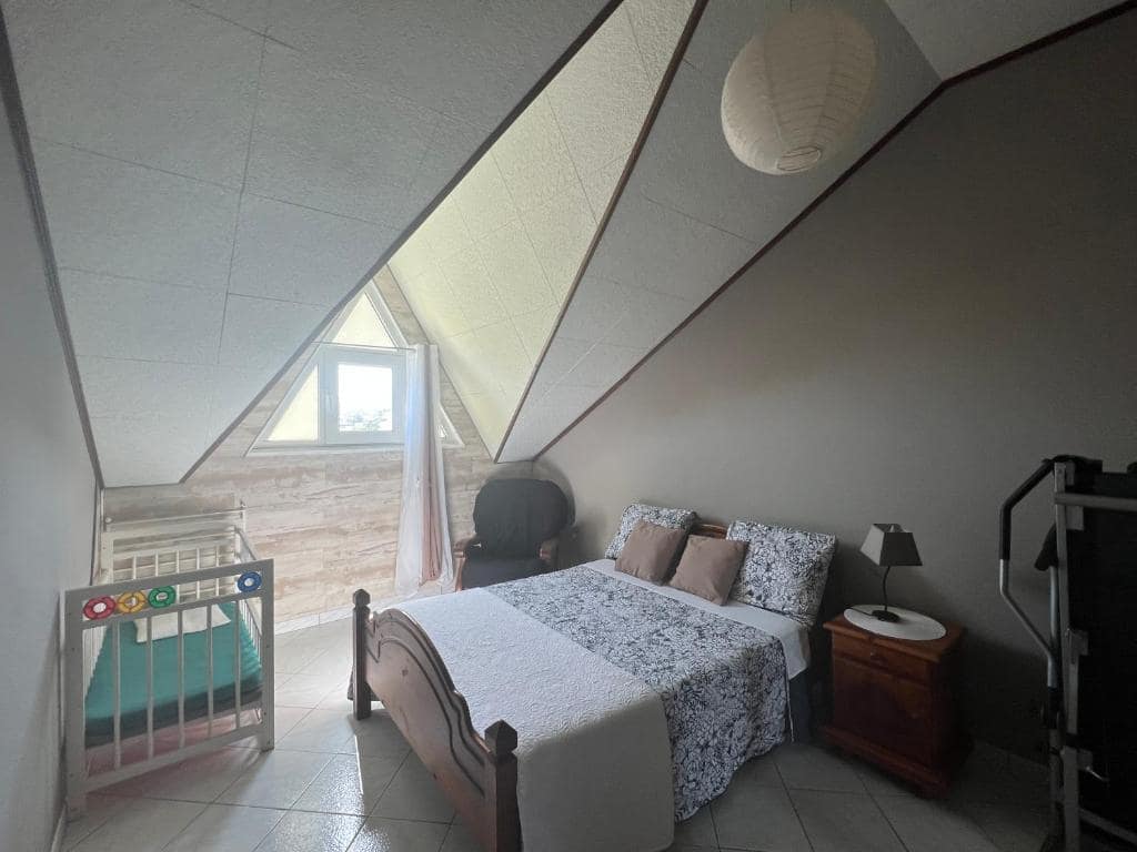 Chambre sous combles avec berceau bébé et lit double · © Le Liseron Créole