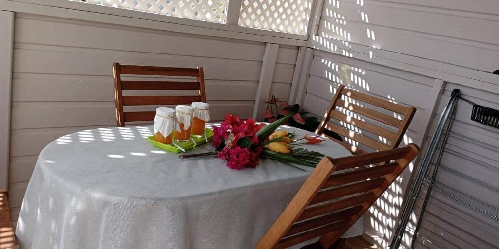 Table dressée sous varangue, panier de bienvenue et bougainvilliers · © Le Liseron Créole
