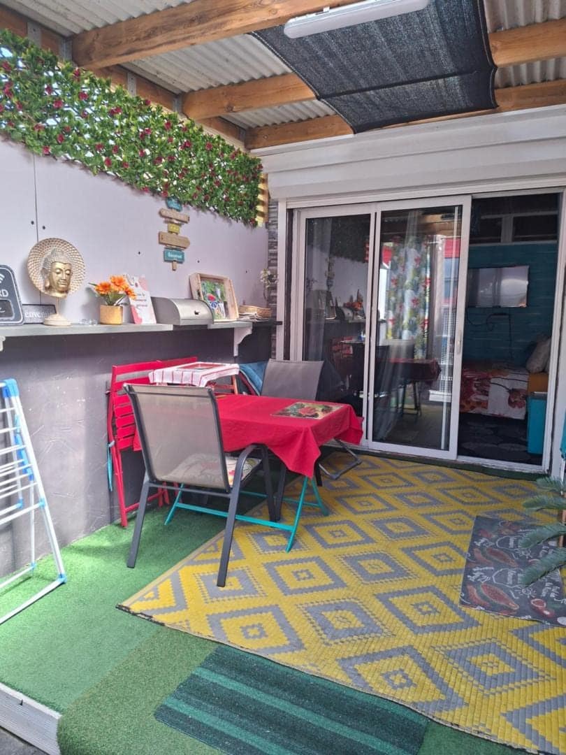 Coin terrasse à la table rouge, décor chiné · © Le Passager Cilaos