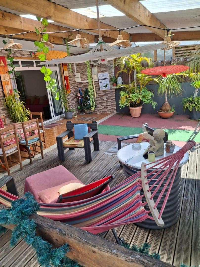 Terrasse fleurie avec hamac et fauteuils · © Le Passager Cilaos