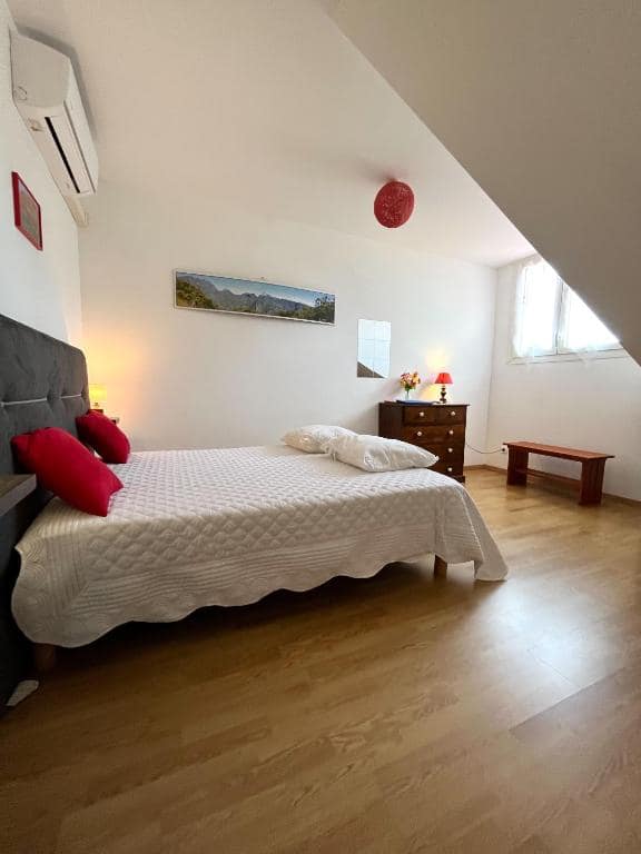 Chambre mansardée avec lit double, table basse et vue montagne encadrée · © Le Quindio