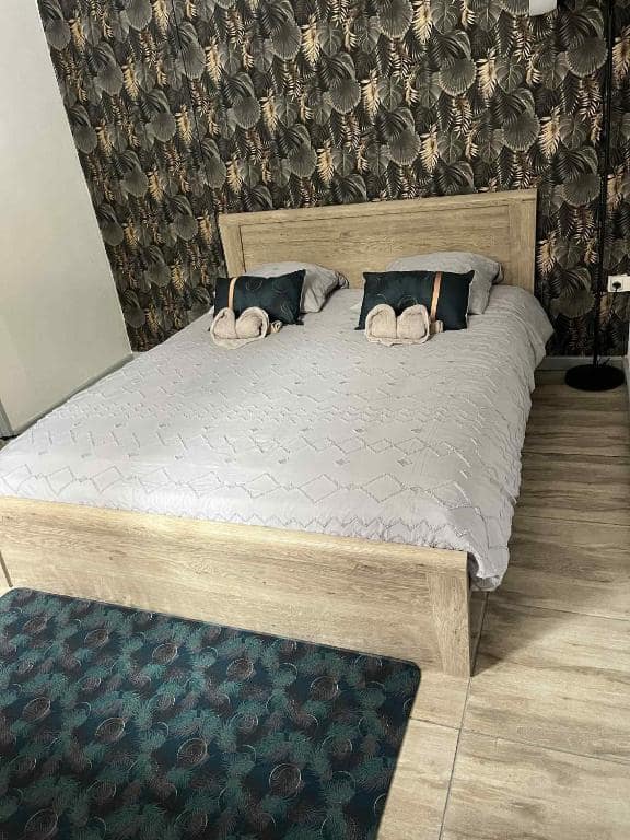 Chambre avec grand lit et papier peint feuillage tropical · © Le repaire de la mare