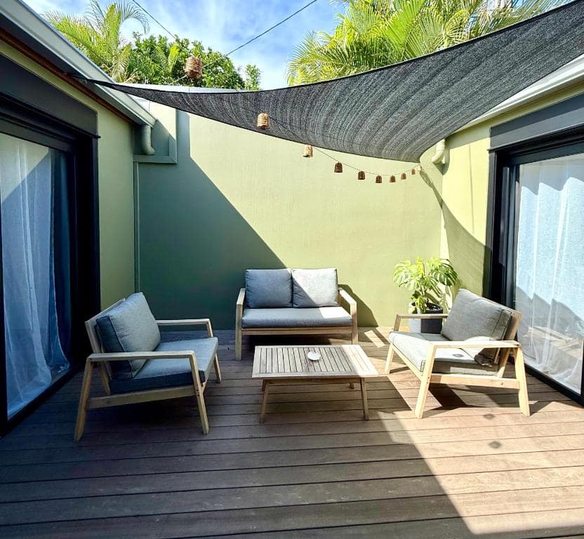 Terrasse en bois, fauteuils sous voile d'ombrage · © Le Sounta