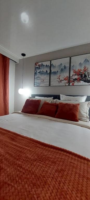 Chambre à grand lit, triptyque montagne au-dessus de la tête de lit · © Le torii