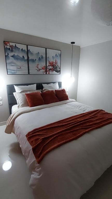 Détail du même couchage, plaid orange saumon et pendulaires côté · © Le torii
