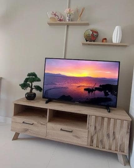 Coin salon avec télévision, bonsaï et éventail sur étagère bois · © Le torii
