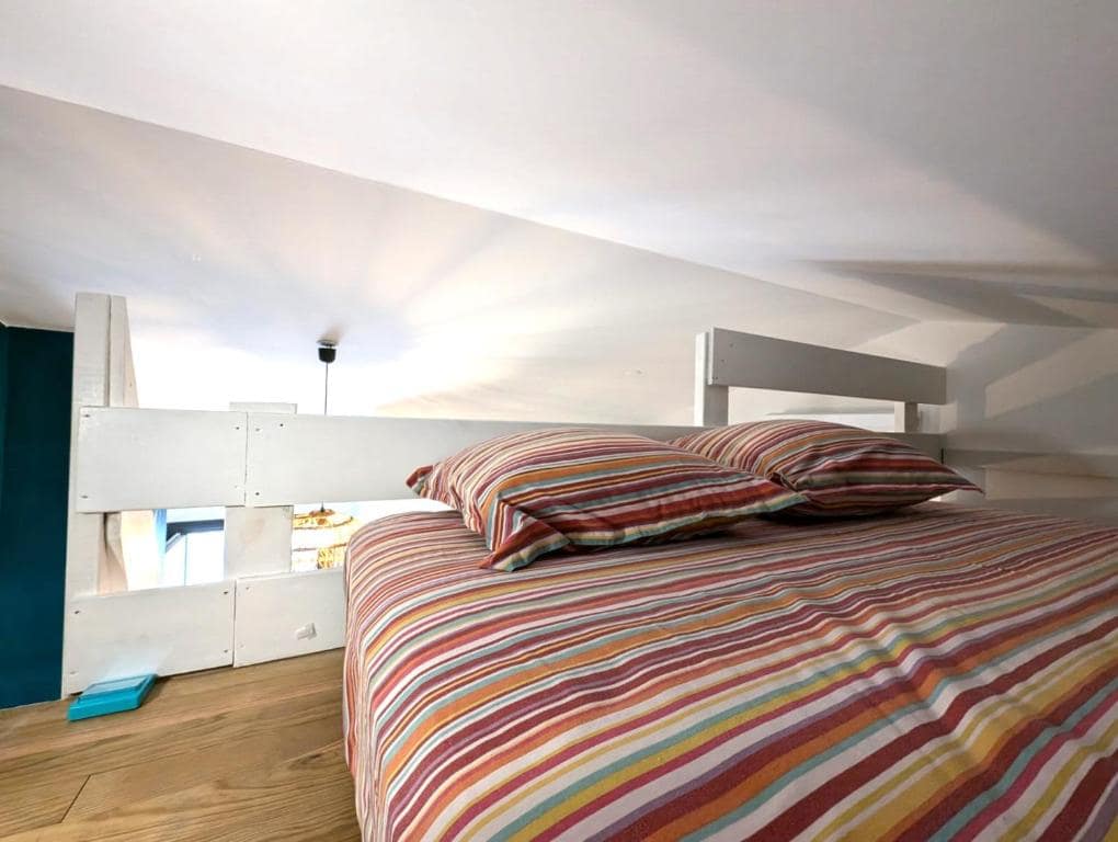 Lit mezzanine sous rampant avec parure à rayures · © Le Zanlik
