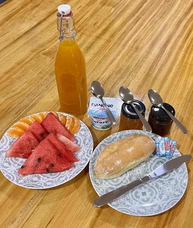 Petit-déjeuner créole : jus d'orange, pastèque, mandarine, pain et yaourt · © Chambres d'hôtes l'écrin de rose