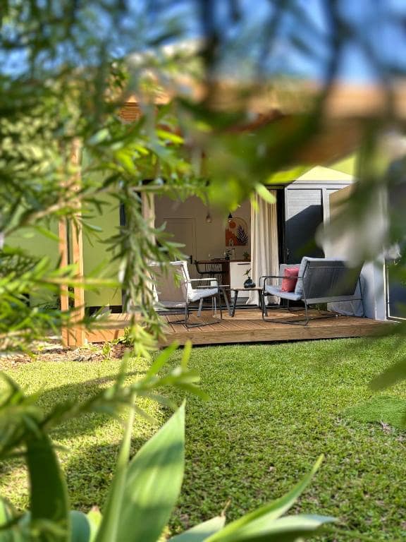 Terrasse en bois avec deux fauteuils, vue jardin planté · © L'Ecrin PEI