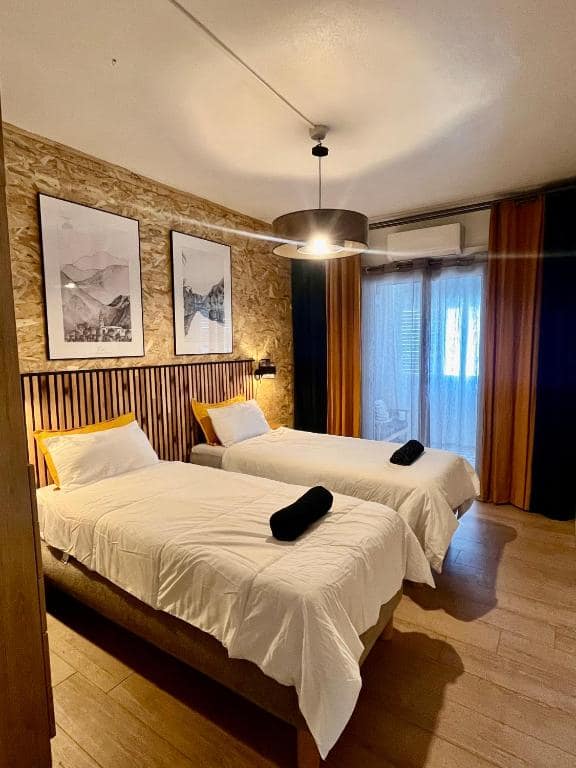 Chambre avec deux lits simples et têtes de lit encadrées · © Lelaleu