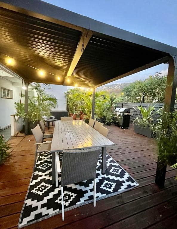Table de repas dressée sous la pergola au crépuscule · © Lelaleu